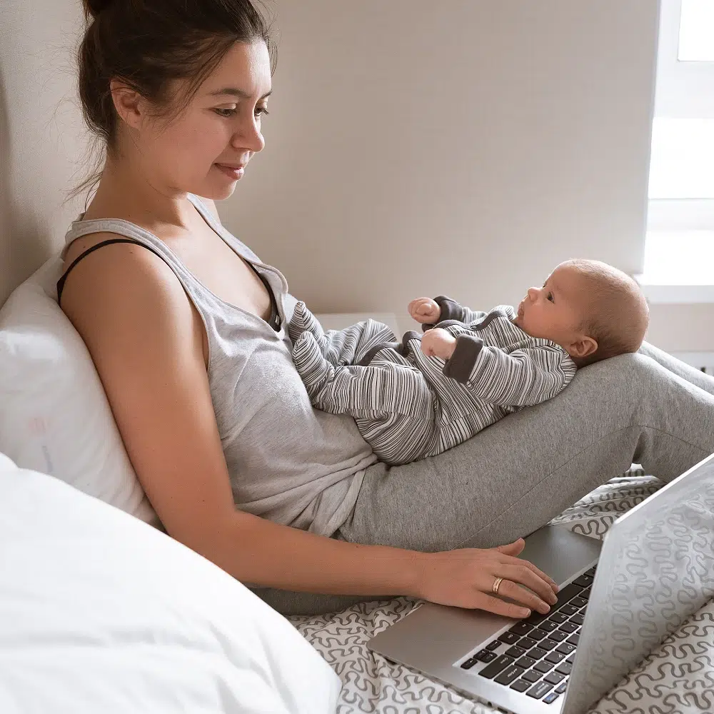 Mère avec bébé sur les genoux utilisant un ordinateur