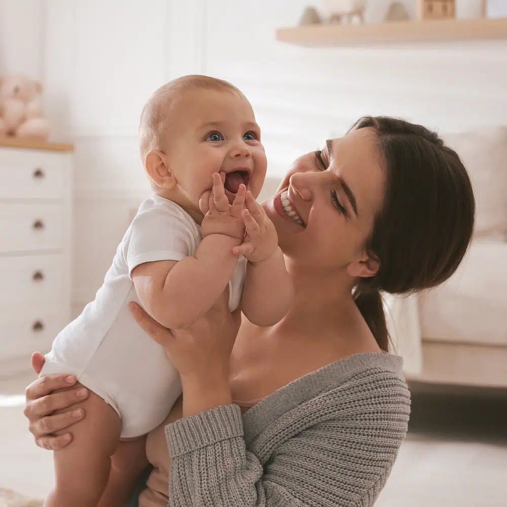 Mère souriante tenant un bébé heureux